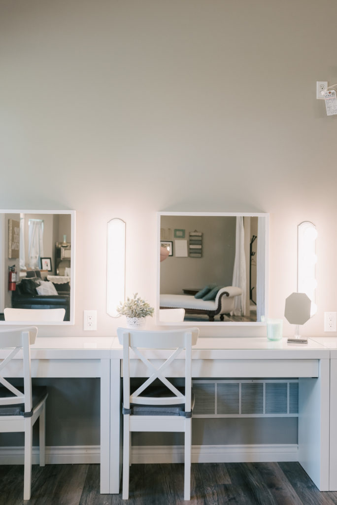 A view of the white vanity with chairs and lighting in the bridal suite