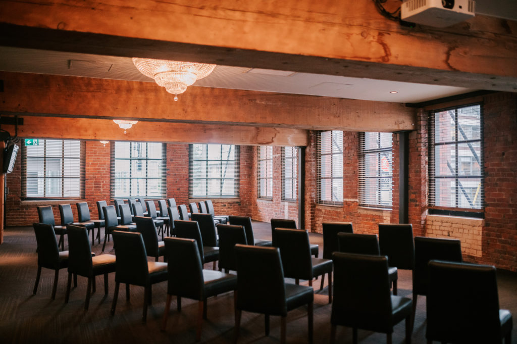 Alternative Vancouver Wedding venue The Loft inside private room set up with black leather chairs for a ceremony
