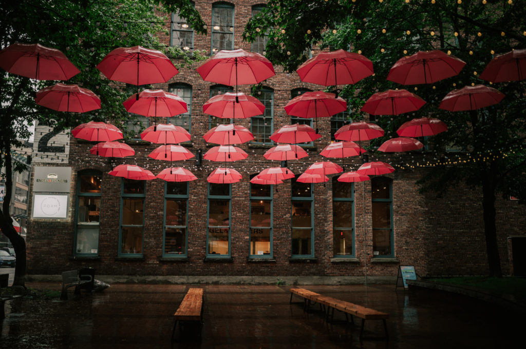 Vancouver wedding photographer: red umbrellas and string lights strung in a dark urban alley