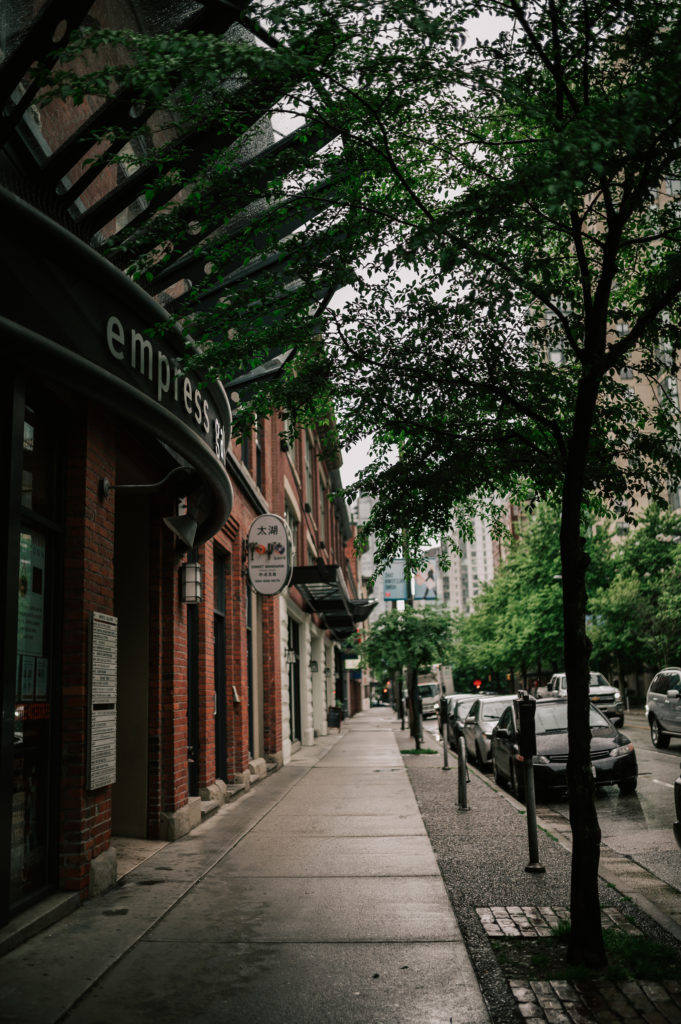 A Vancouver side street with historic buildings and green trees